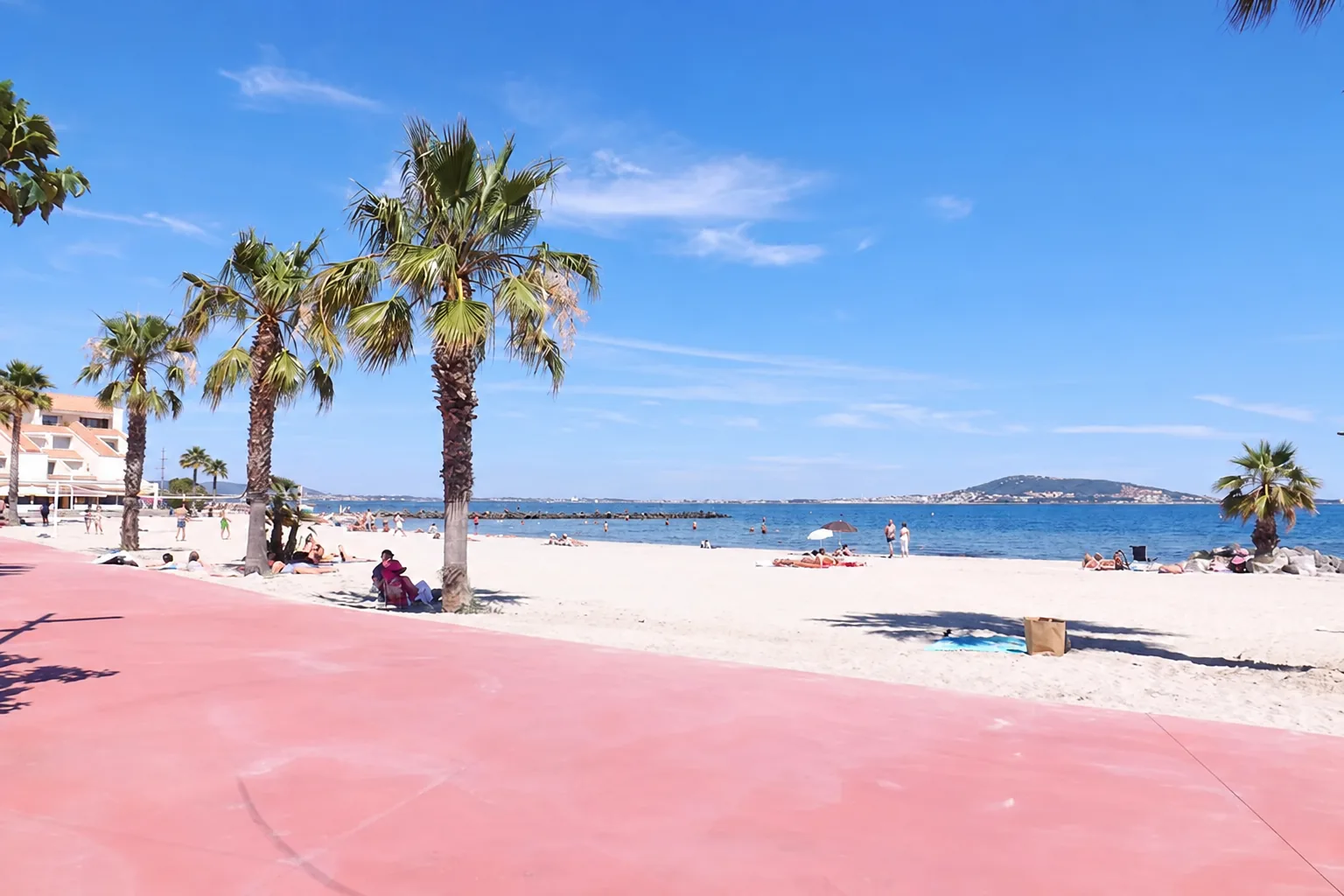 Plage de Mèze au bord de l’étang de Thau avec palmiers et promenade
